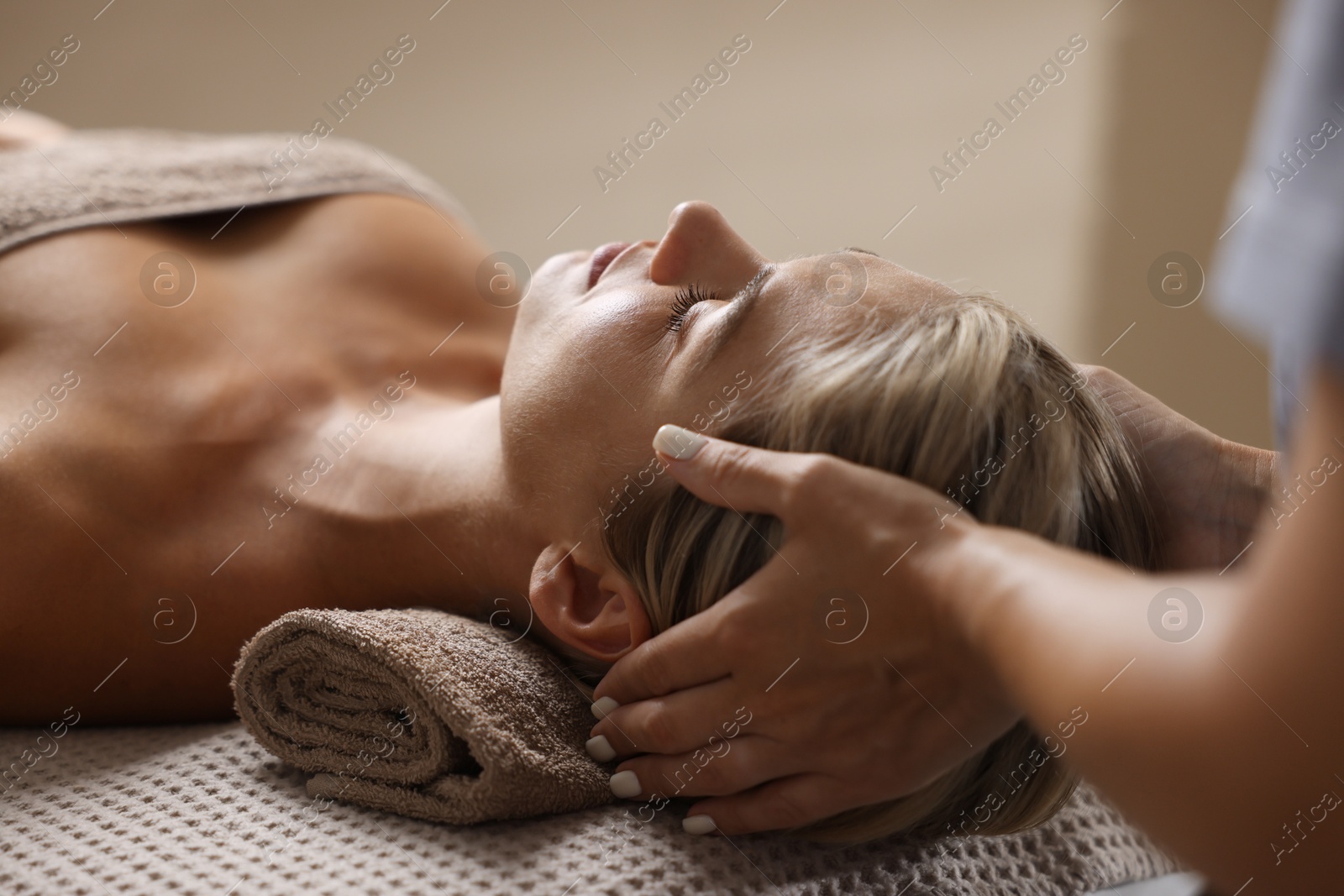 Beautiful woman receiving facial massage on couch indoors, closeup Photo of Beautiful woman receiving facial massage on couch indoors, closeup