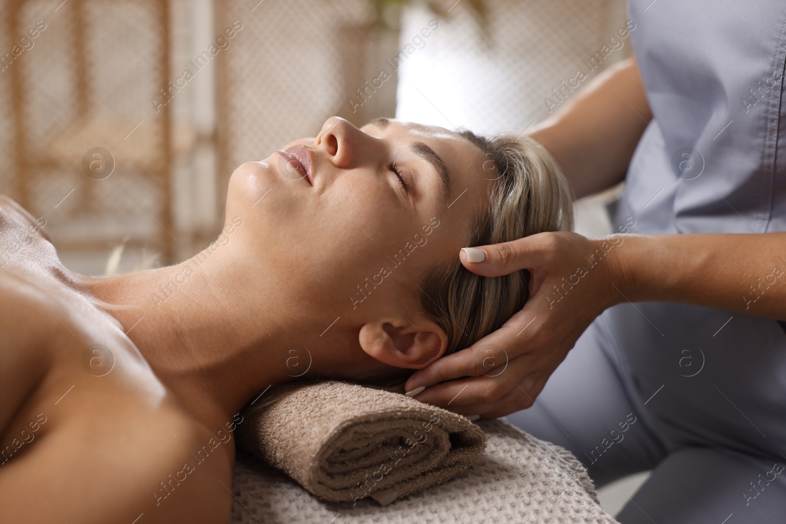 Beautiful woman receiving facial massage on couch in spa salon, closeup Photo of Beautiful woman receiving facial massage on couch in spa salon, closeup