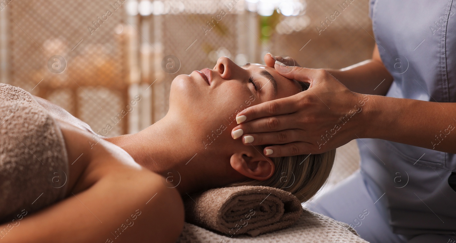 Beautiful woman receiving facial massage on couch in spa salon, closeup Photo of Beautiful woman receiving facial massage on couch in spa salon, closeup