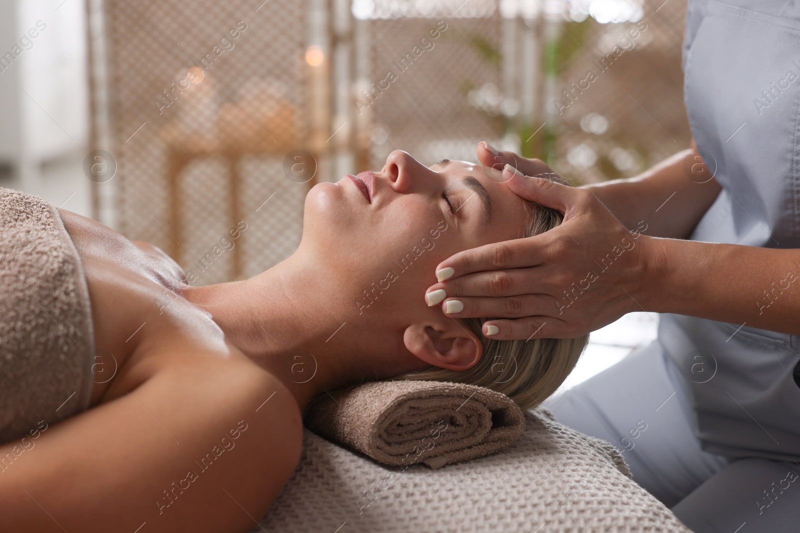 Beautiful woman receiving facial massage on couch in spa salon, closeup Photo of Beautiful woman receiving facial massage on couch in spa salon, closeup