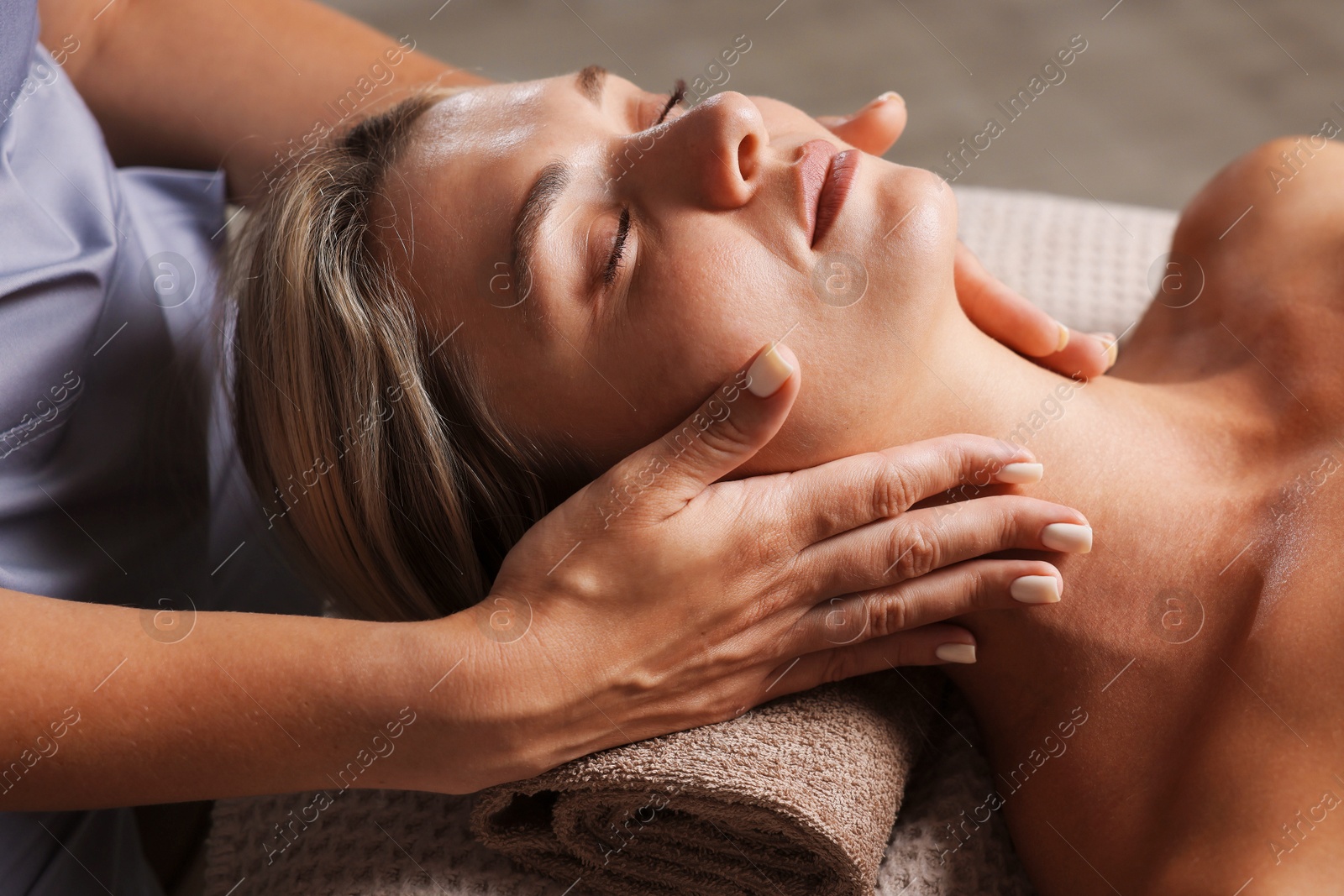 Beautiful woman receiving facial massage on couch, closeup Photo of Beautiful woman receiving facial massage on couch, closeup