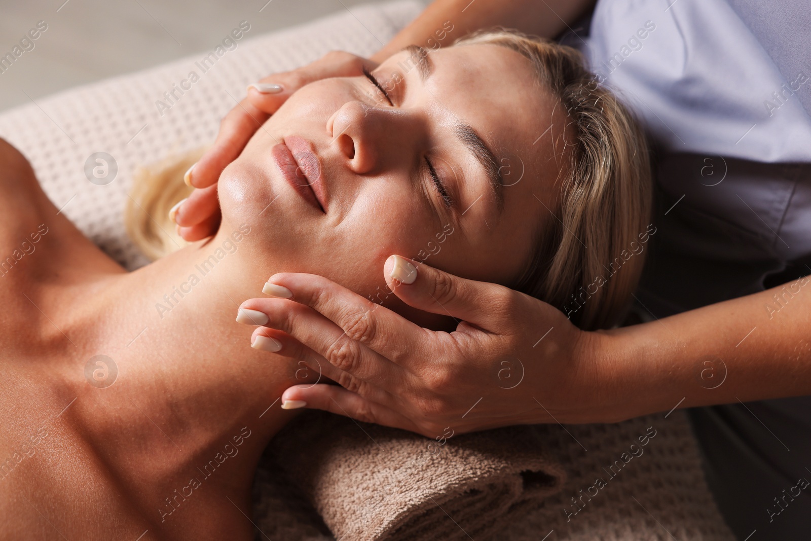 Beautiful woman receiving facial massage on couch, closeup Photo of Beautiful woman receiving facial massage on couch, closeup