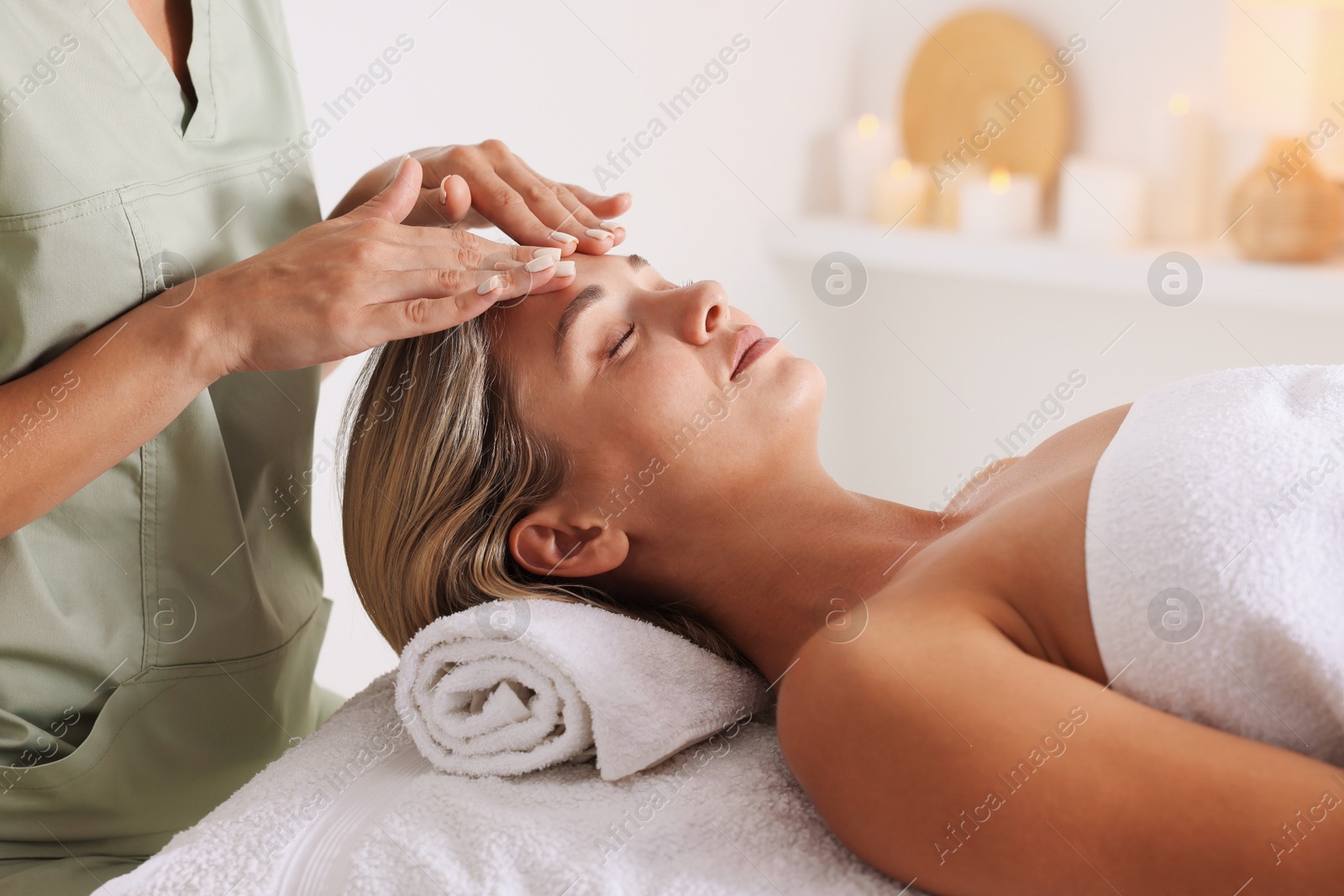 Beautiful woman receiving facial massage on couch in spa salon, closeup Photo of Beautiful woman receiving facial massage on couch in spa salon, closeup