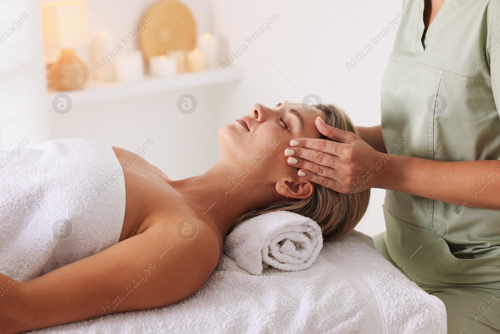 Beautiful woman receiving facial massage on couch in spa salon, closeup Photo of Beautiful woman receiving facial massage on couch in spa salon, closeup