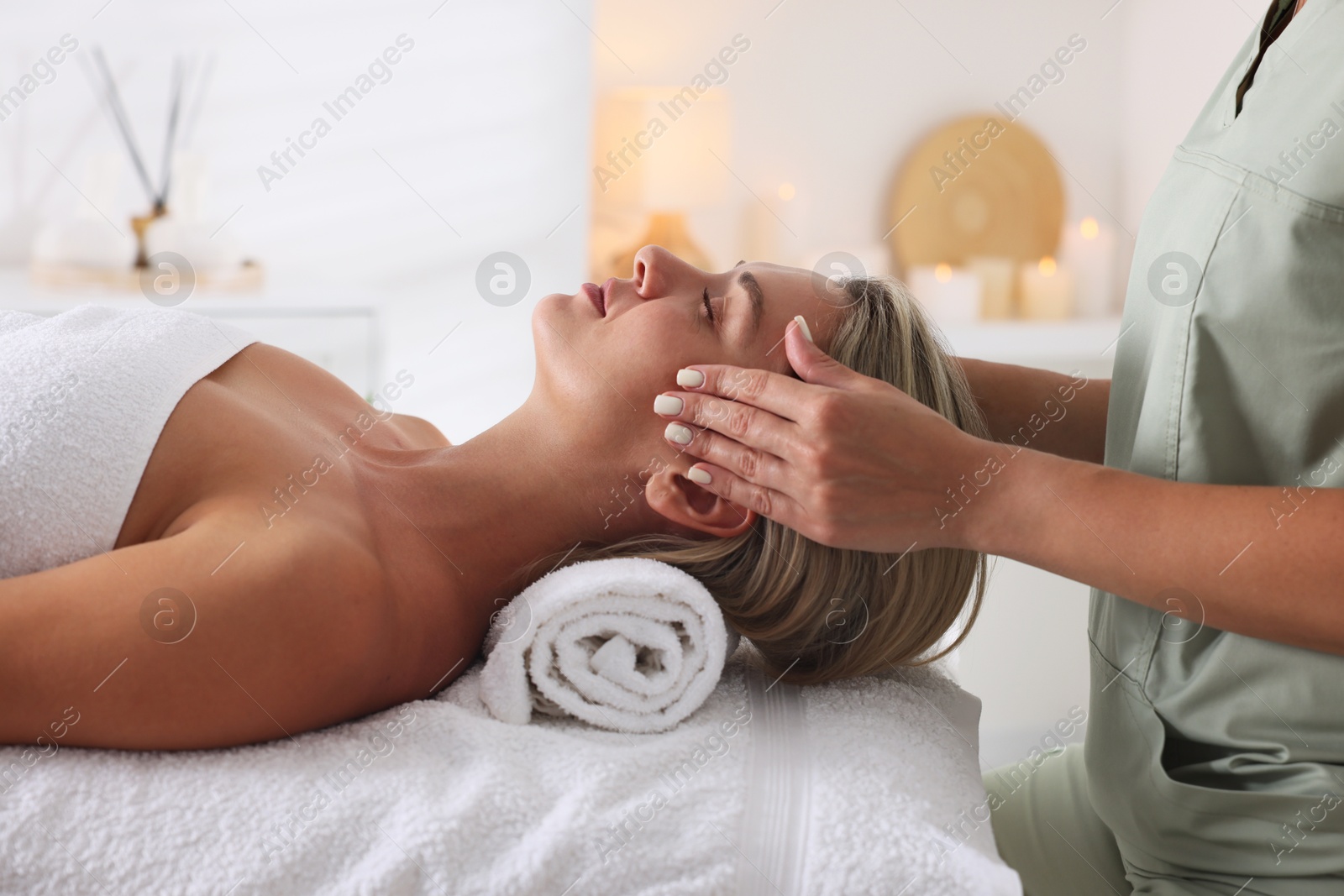 Beautiful woman receiving facial massage on couch in spa salon, closeup Photo of Beautiful woman receiving facial massage on couch in spa salon, closeup