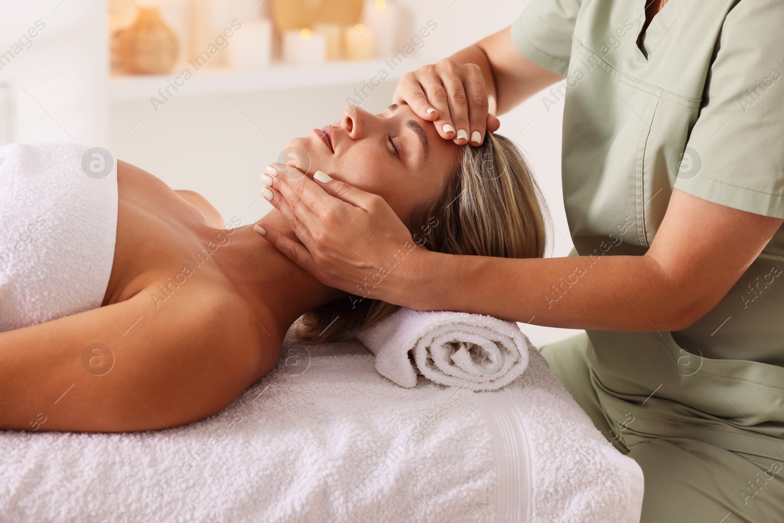Beautiful woman receiving facial massage on couch in spa salon, closeup Photo of Beautiful woman receiving facial massage on couch in spa salon, closeup