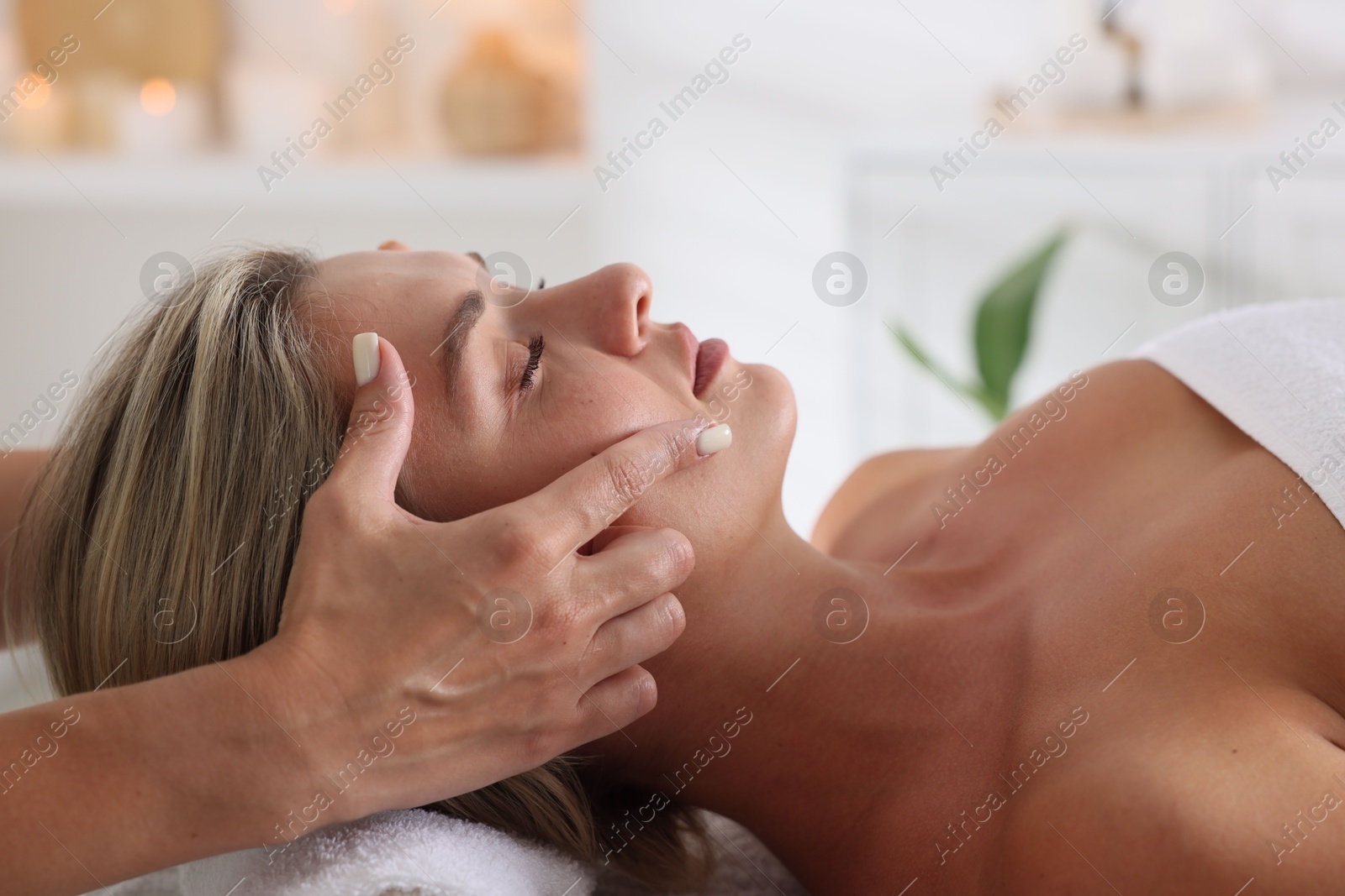 Beautiful woman receiving facial massage in spa salon, closeup Photo of Beautiful woman receiving facial massage in spa salon, closeup