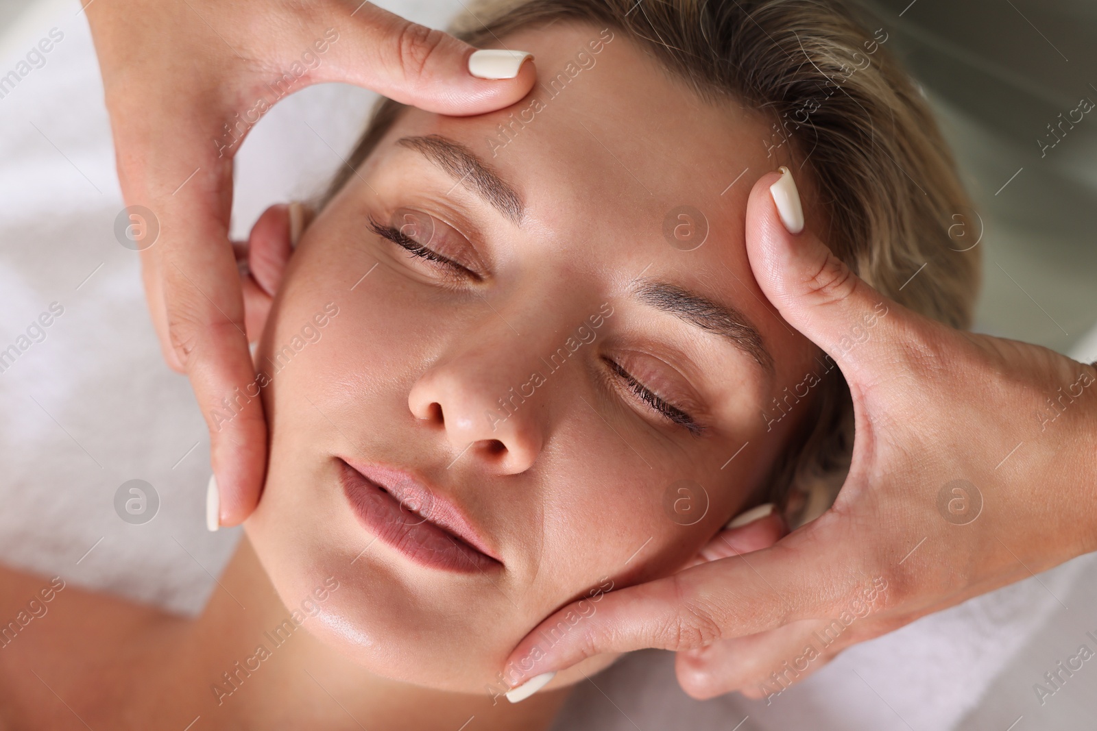 Beautiful woman receiving facial massage, closeup view Photo of Beautiful woman receiving facial massage, closeup view