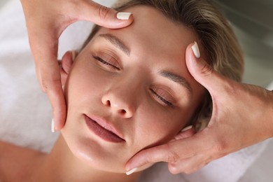 Photo of Beautiful woman receiving facial massage, closeup view