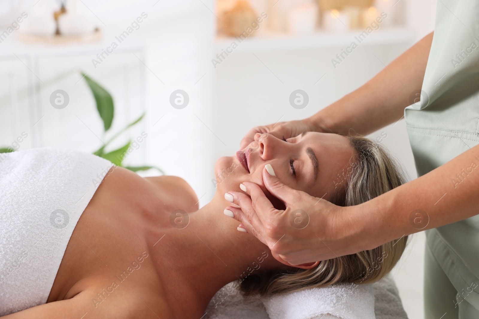 Beautiful woman receiving facial massage in spa salon, closeup Photo of Beautiful woman receiving facial massage in spa salon, closeup