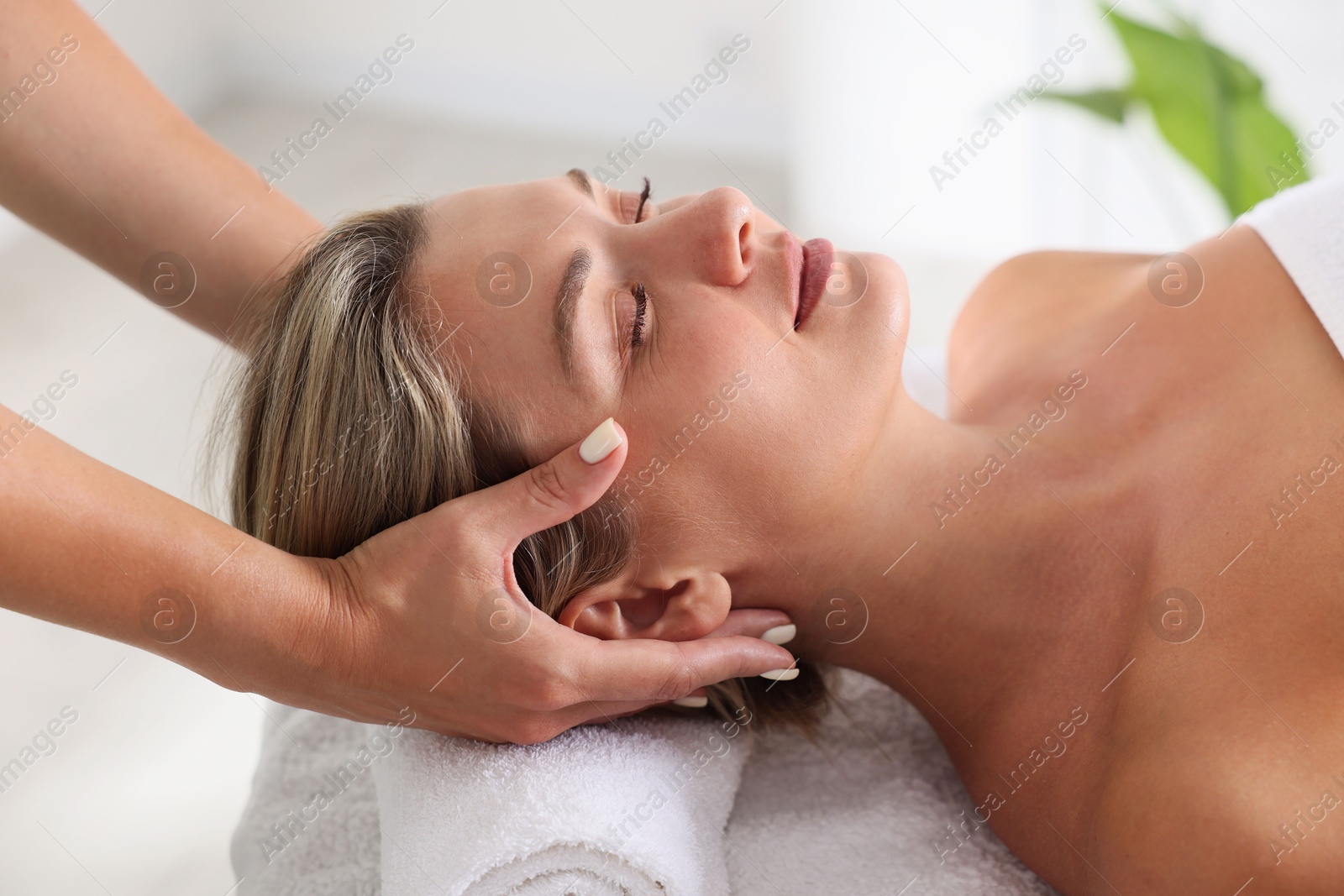 Beautiful woman receiving facial massage on couch indoors, closeup Photo of Beautiful woman receiving facial massage on couch indoors, closeup