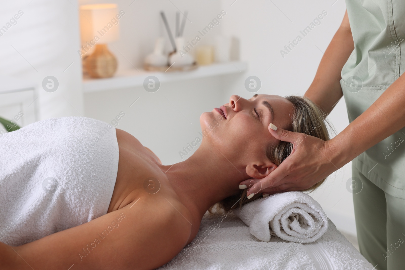 Beautiful woman receiving facial massage on couch in spa salon, closeup Photo of Beautiful woman receiving facial massage on couch in spa salon, closeup