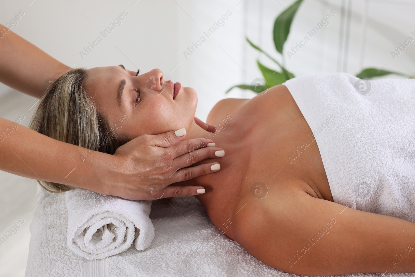Beautiful woman receiving facial massage on couch in spa salon, closeup Photo of Beautiful woman receiving facial massage on couch in spa salon, closeup