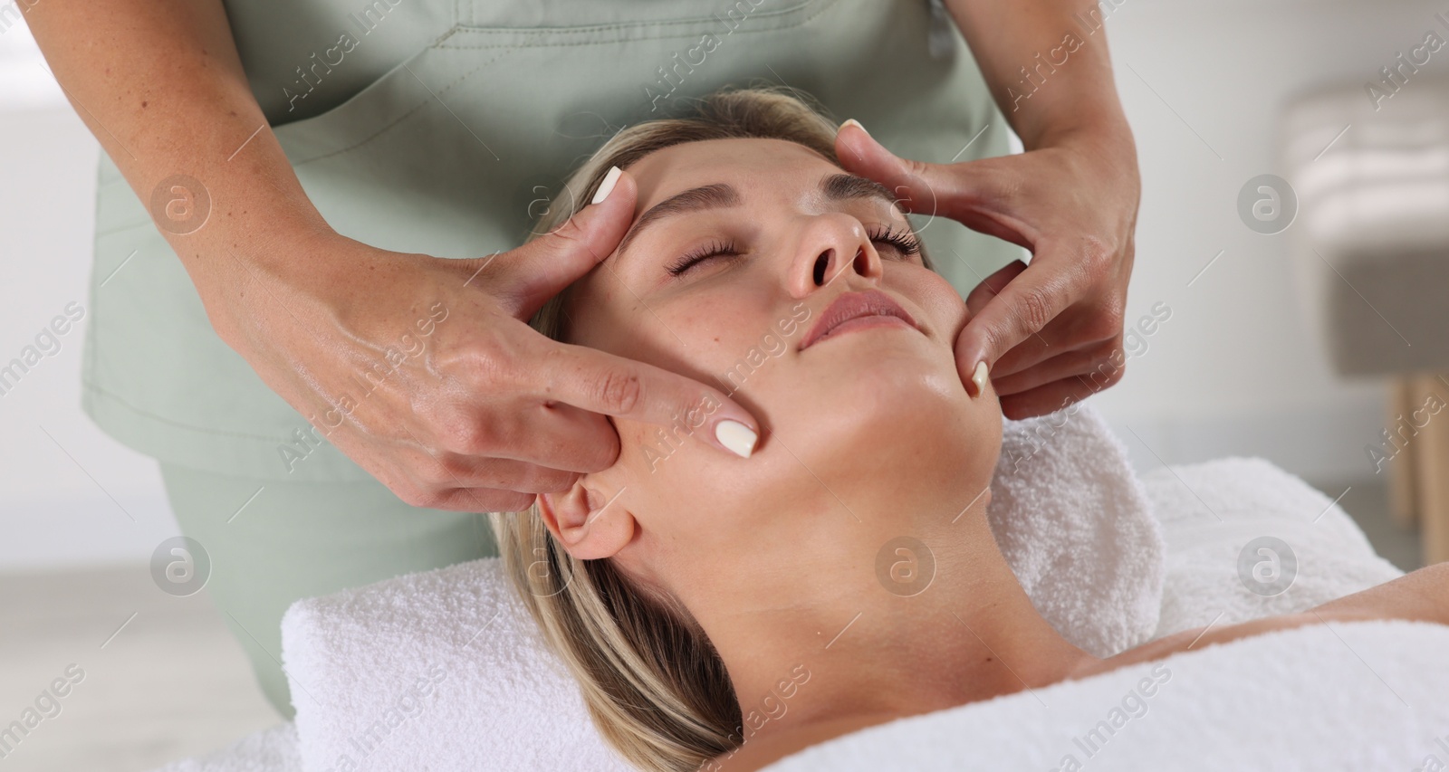 Beautiful woman receiving facial massage indoors, closeup Photo of Beautiful woman receiving facial massage indoors, closeup