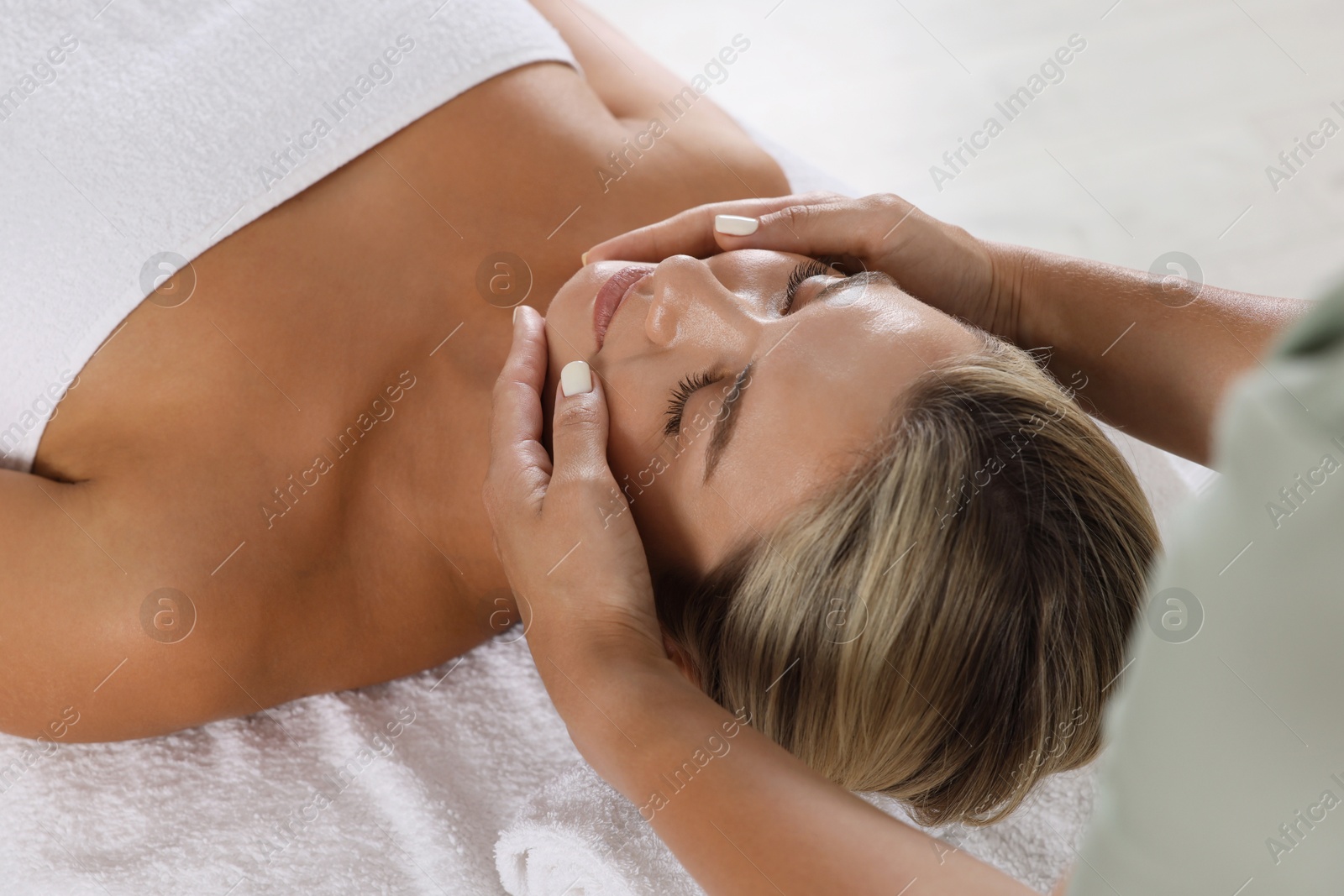 Beautiful woman receiving facial massage indoors, closeup Photo of Beautiful woman receiving facial massage indoors, closeup