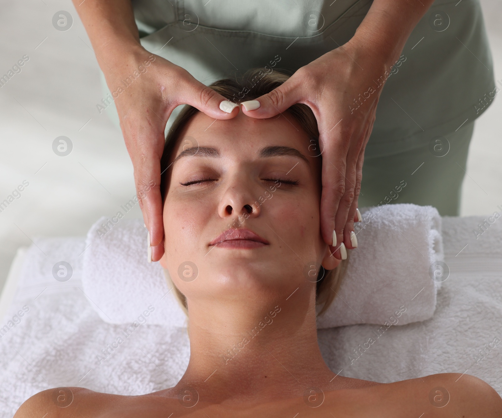 Beautiful woman receiving facial massage on couch indoors, closeup Photo of Beautiful woman receiving facial massage on couch indoors, closeup
