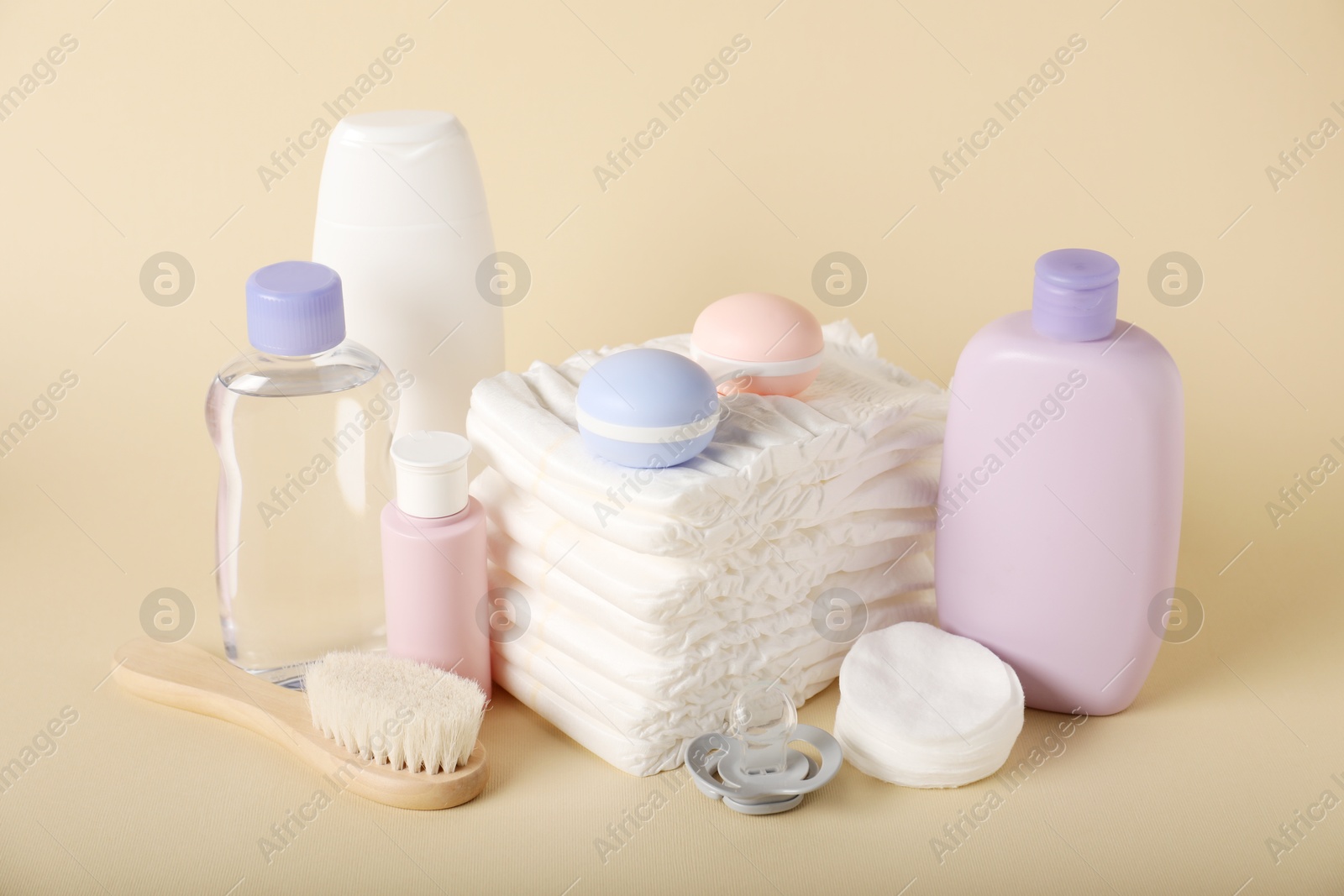 Baby accessories and cosmetic products on beige background Photo of Baby accessories and cosmetic products on beige background