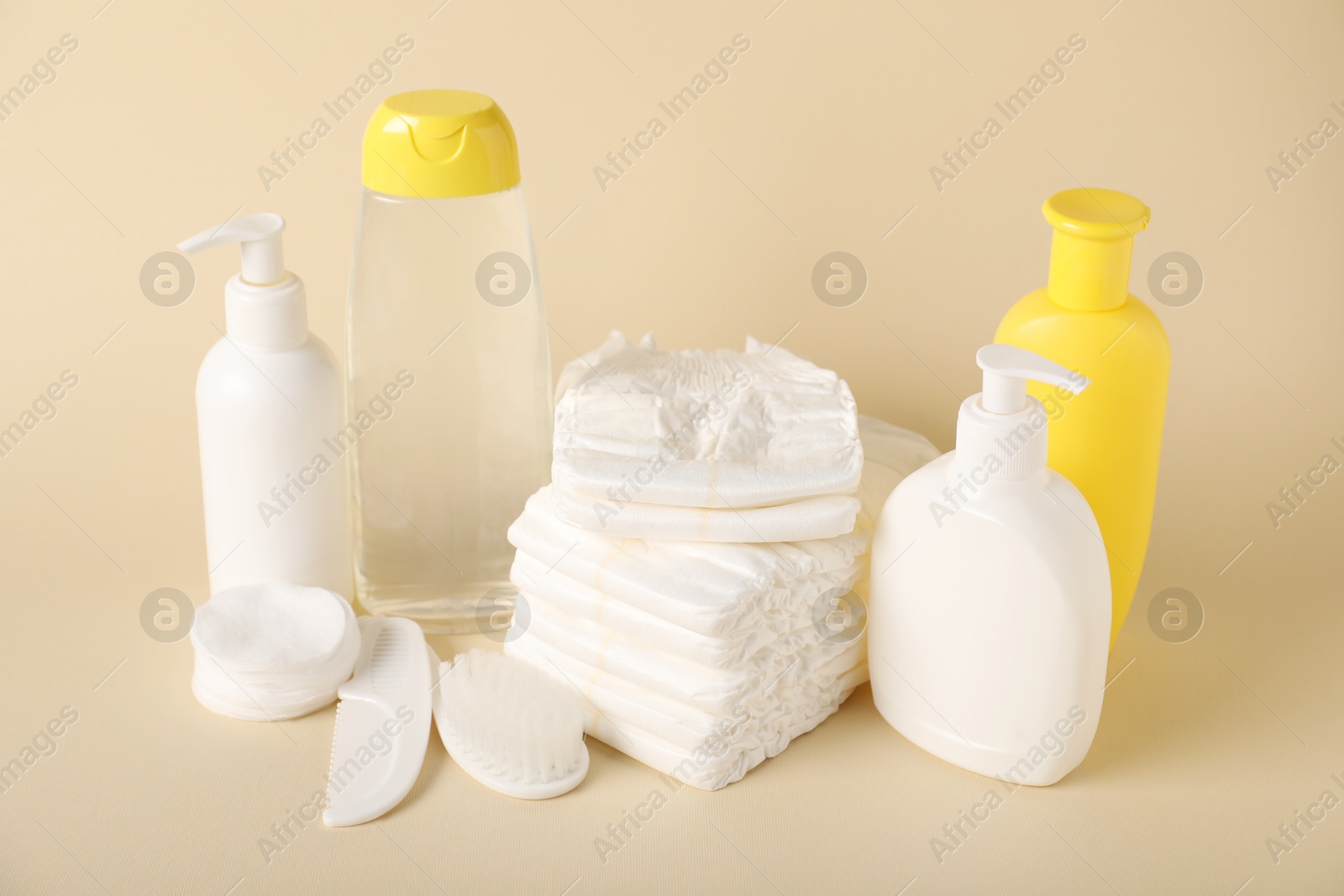 Baby accessories and cosmetic products on beige background Photo of Baby accessories and cosmetic products on beige background