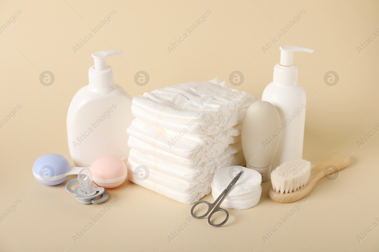 Baby accessories and cosmetic products on beige background Photo of Baby accessories and cosmetic products on beige background