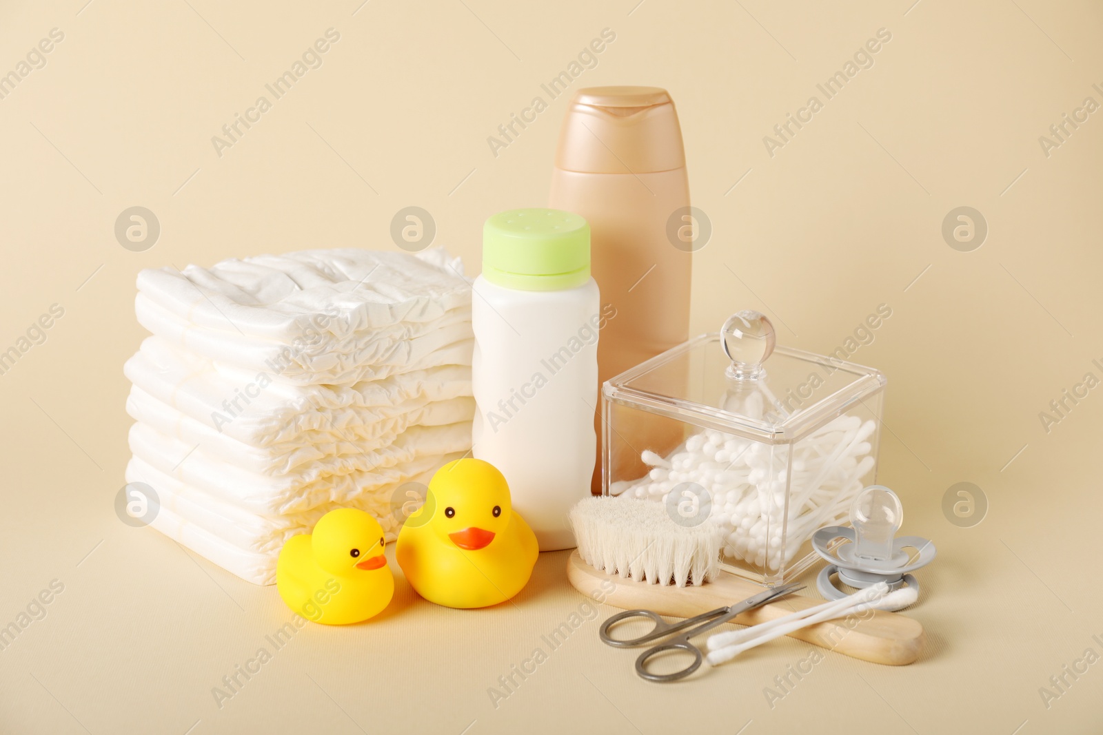 Baby accessories and cosmetic products on beige background Photo of Baby accessories and cosmetic products on beige background