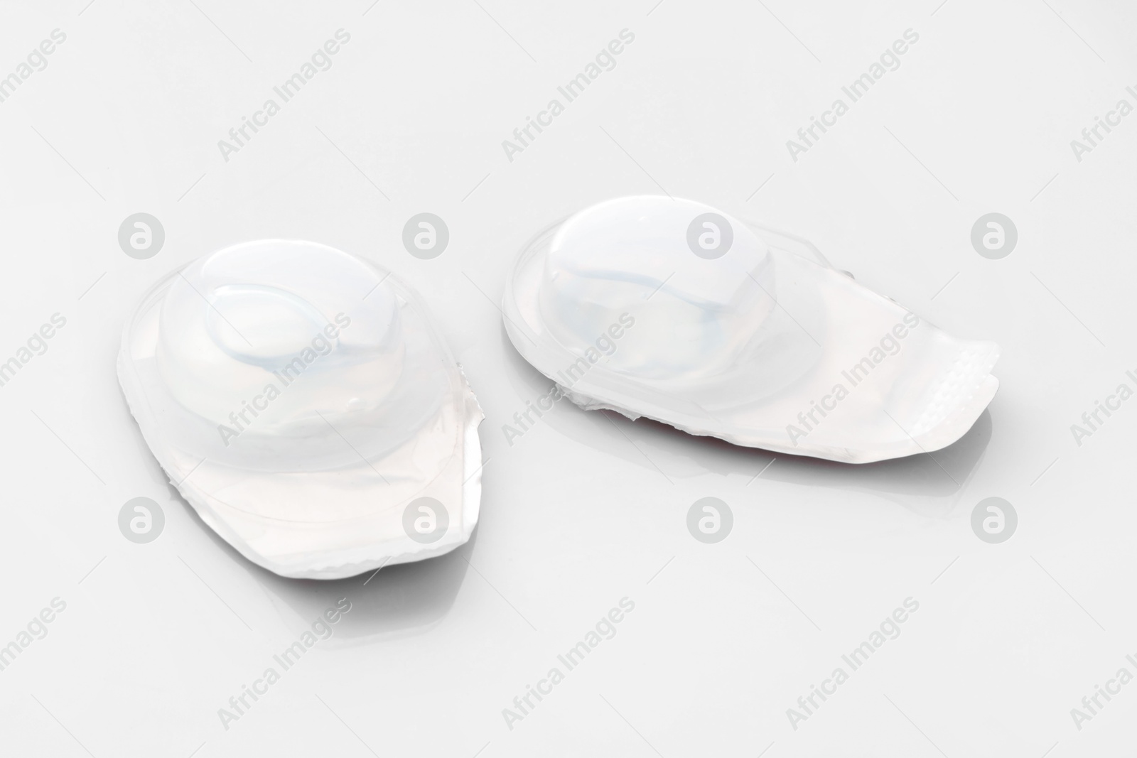 Blister packs with contact lenses on white background Photo of Blister packs with contact lenses on white background