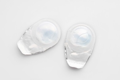 Photo of Blister packs with contact lenses on white background, flat lay