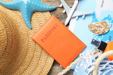 Photo of Time for summer vacation. World map, passport, toy plane and beach accessories on wooden table, flat lay