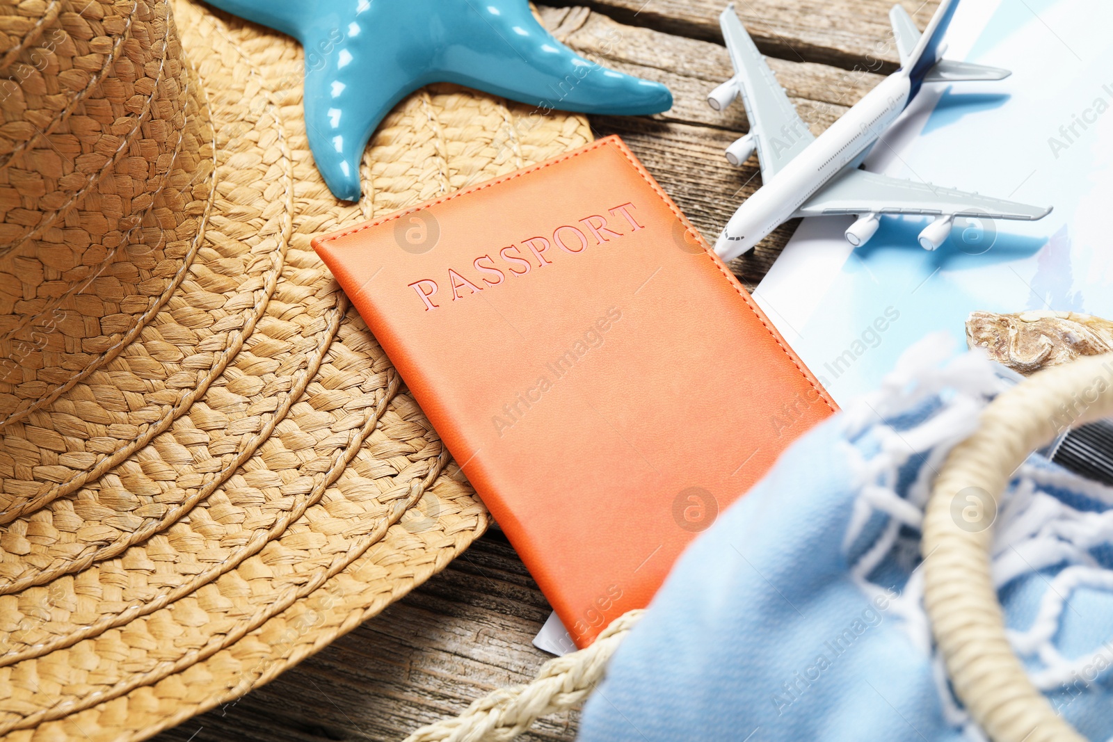Photo of Time for summer vacation. World map, passport, toy plane and beach accessories on wooden table, closeup