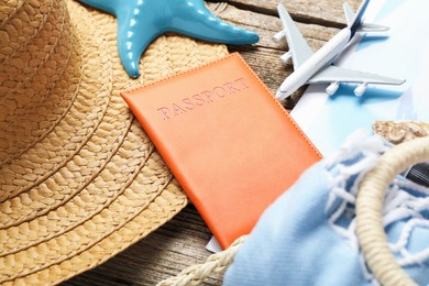 Photo of Time for summer vacation. World map, passport, toy plane and beach accessories on wooden table, closeup