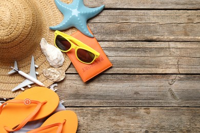 Photo of Time for summer vacation. World map, passport, toy plane and beach accessories on wooden table, flat lay. Space for text