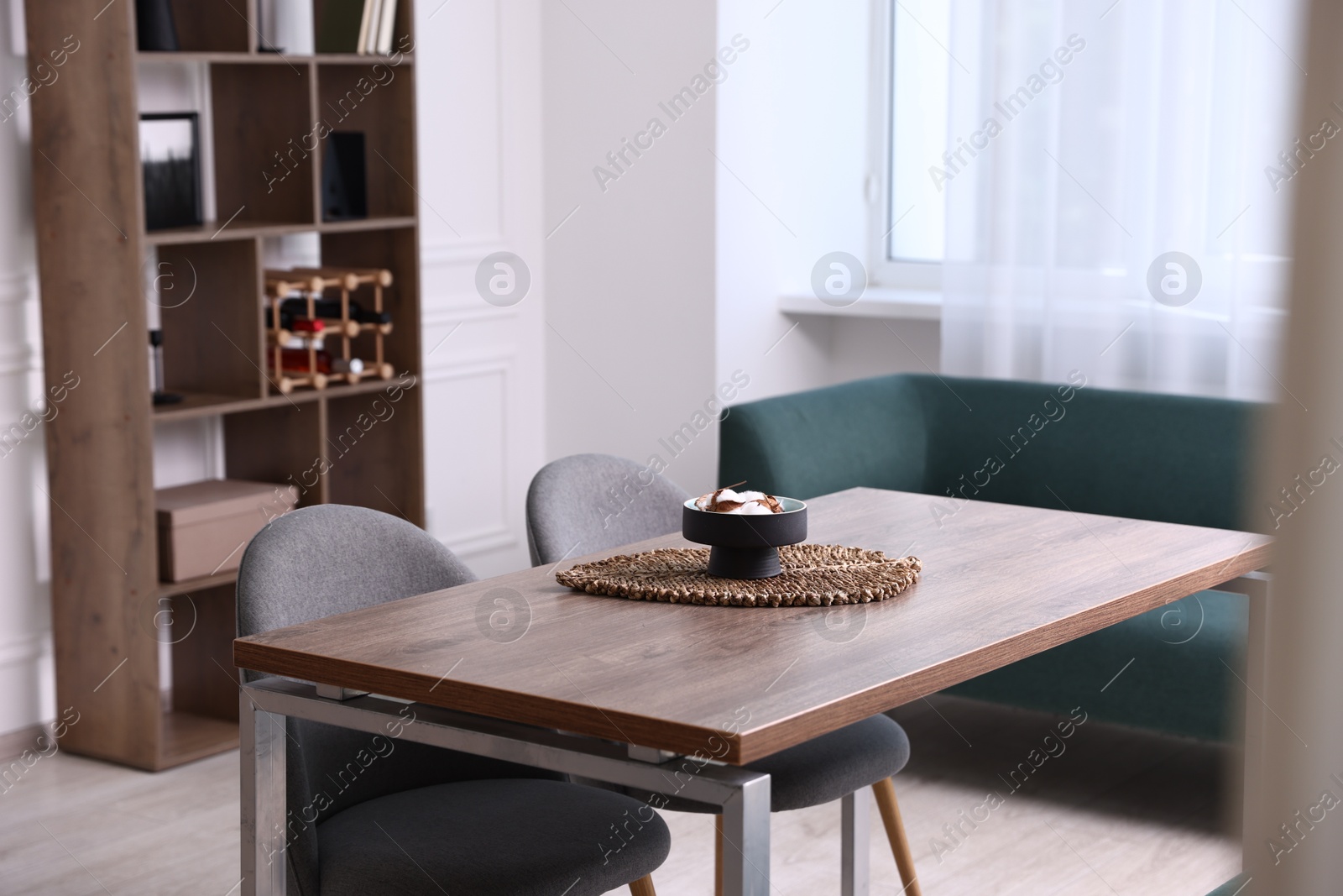 Wooden table with chairs and decor in dining room. Interior design Photo of Wooden table with chairs and decor in dining room. Interior design