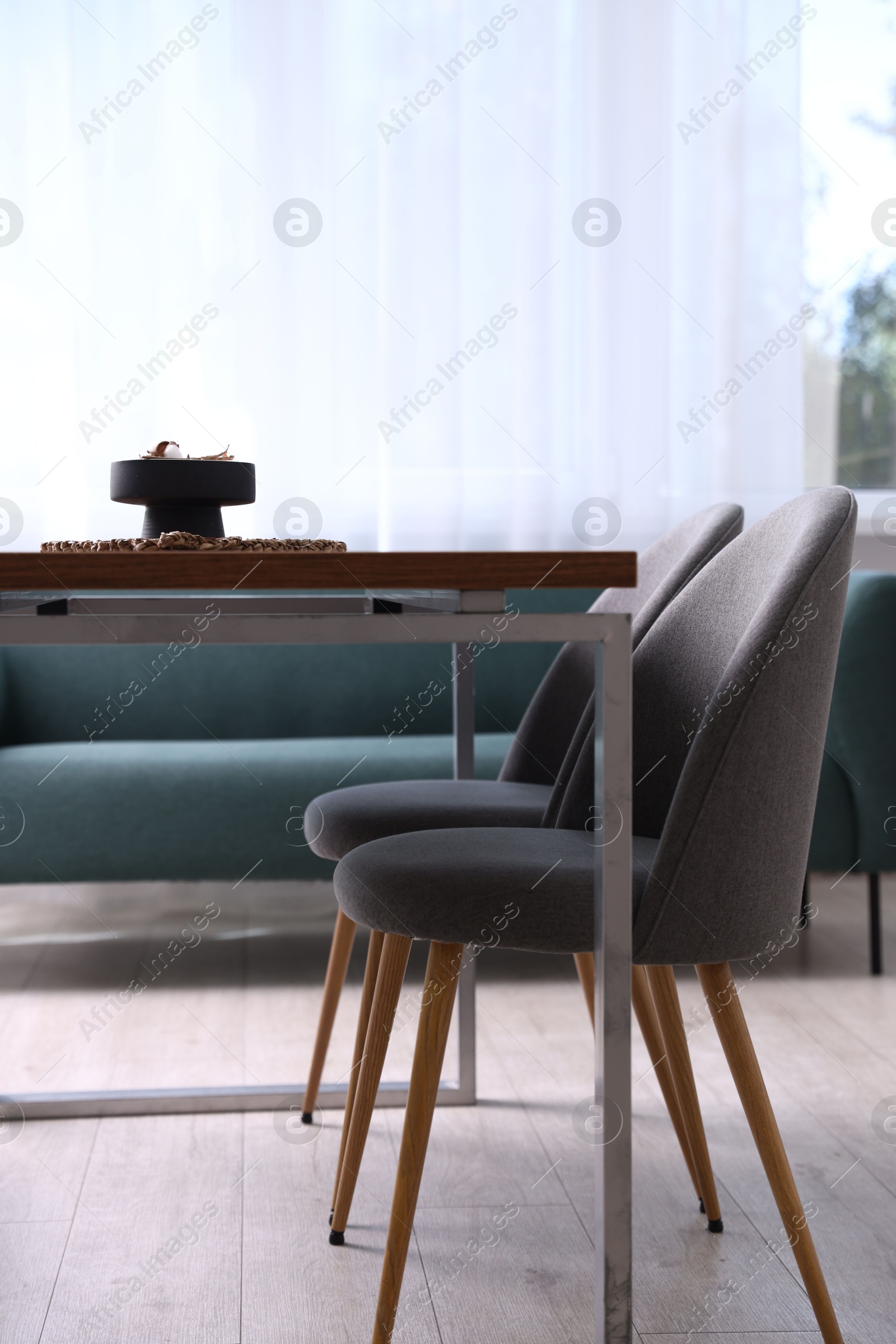 Photo of Wooden table with chairs and decor in dining room. Interior design