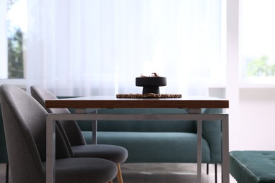 Photo of Wooden table with chairs, bench and decor in dining room. Interior design
