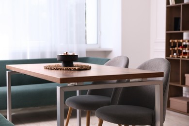 Photo of Wooden table with chairs and decor in dining room. Interior design