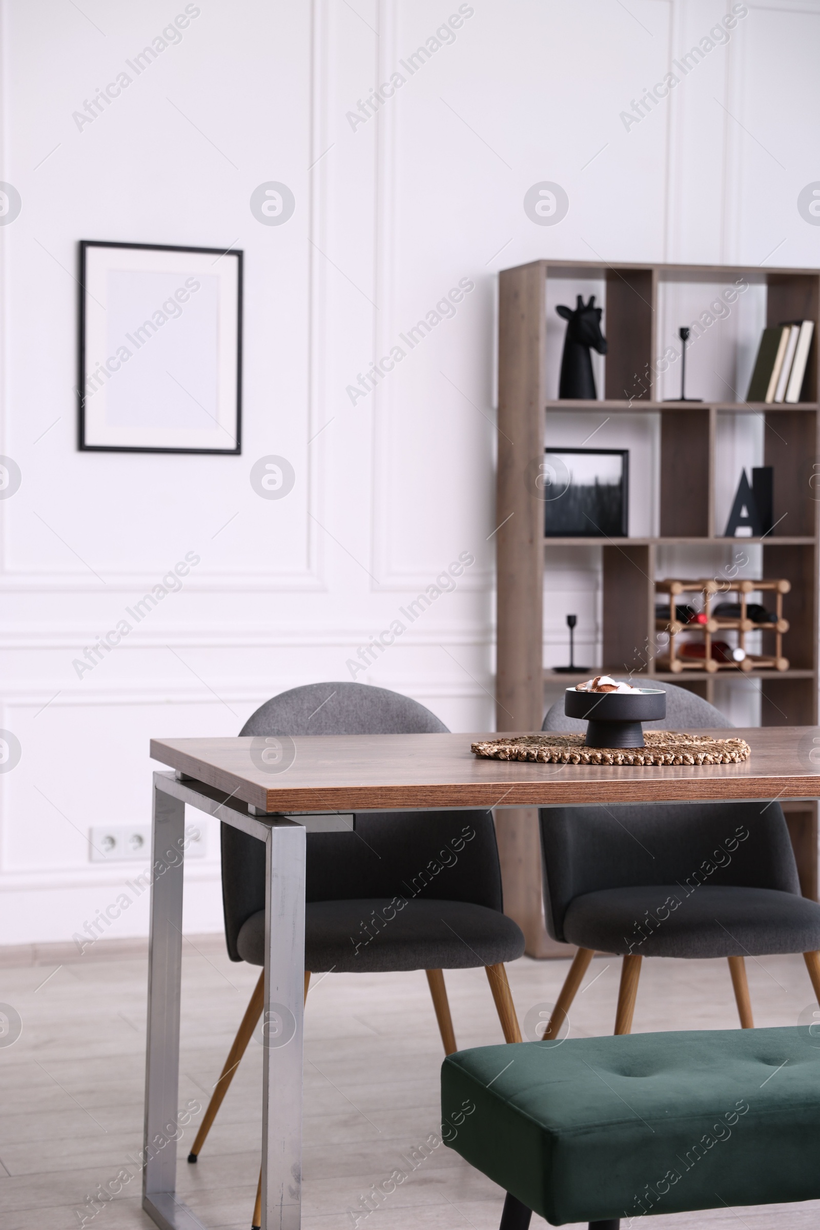 Wooden table with chairs, bench and decor in dining room. Interior design Photo of Wooden table with chairs, bench and decor in dining room. Interior design