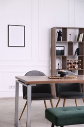 Photo of Wooden table with chairs, bench and decor in dining room. Interior design