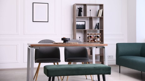 Photo of Wooden table with chairs, bench and decor in dining room. Interior design
