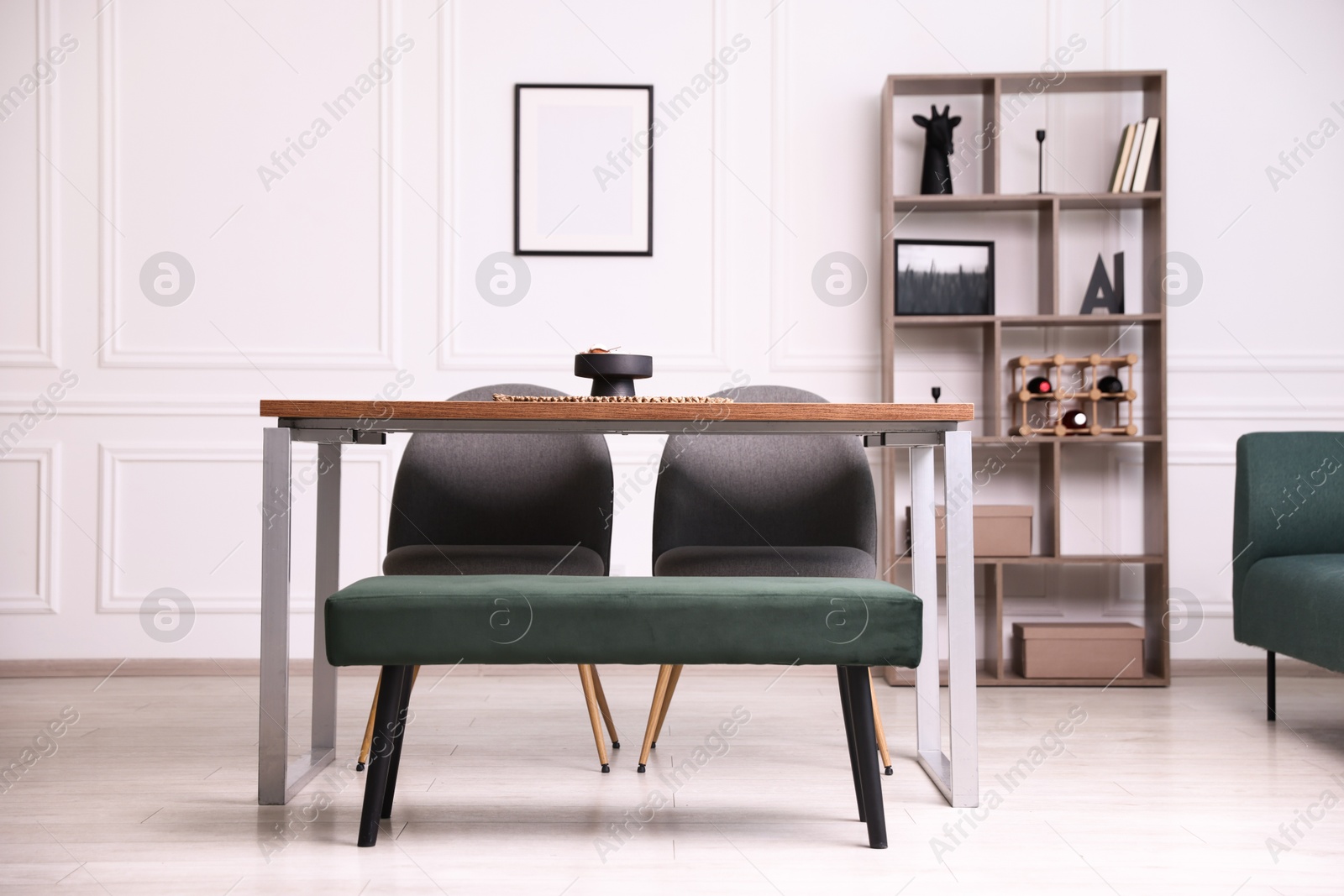 Photo of Wooden table with chairs, bench and decor in dining room. Interior design