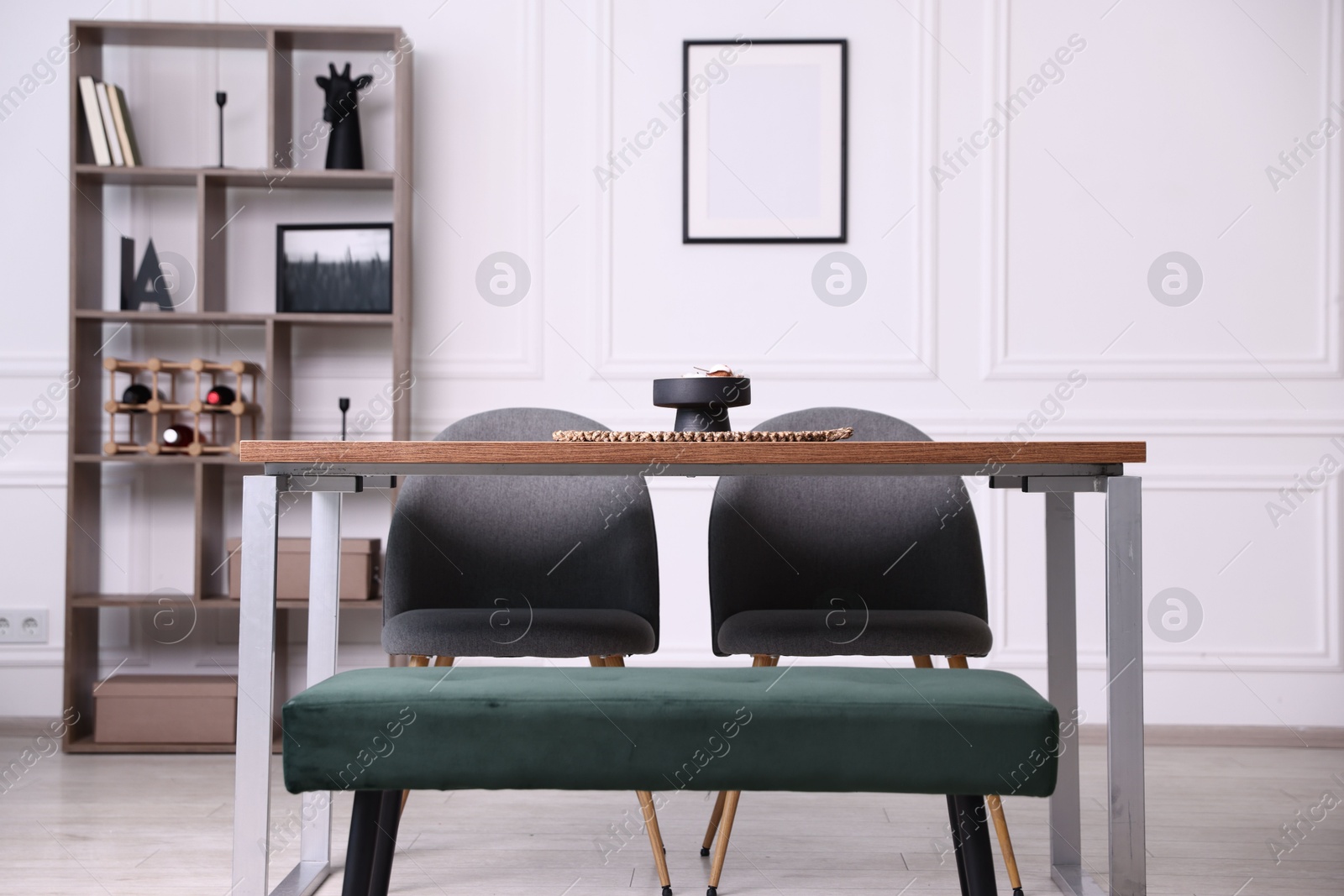 Wooden table with chairs, bench and decor in dining room. Interior design Photo of Wooden table with chairs, bench and decor in dining room. Interior design