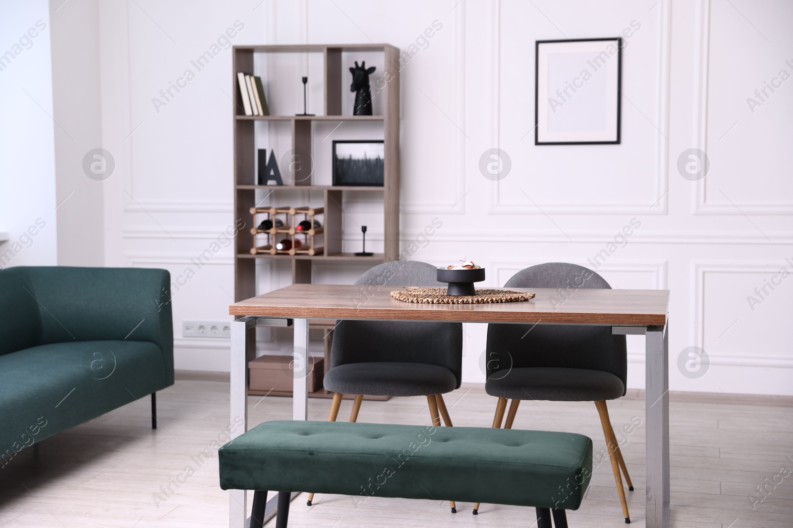Wooden table with chairs, bench and decor in dining room. Interior design Photo of Wooden table with chairs, bench and decor in dining room. Interior design