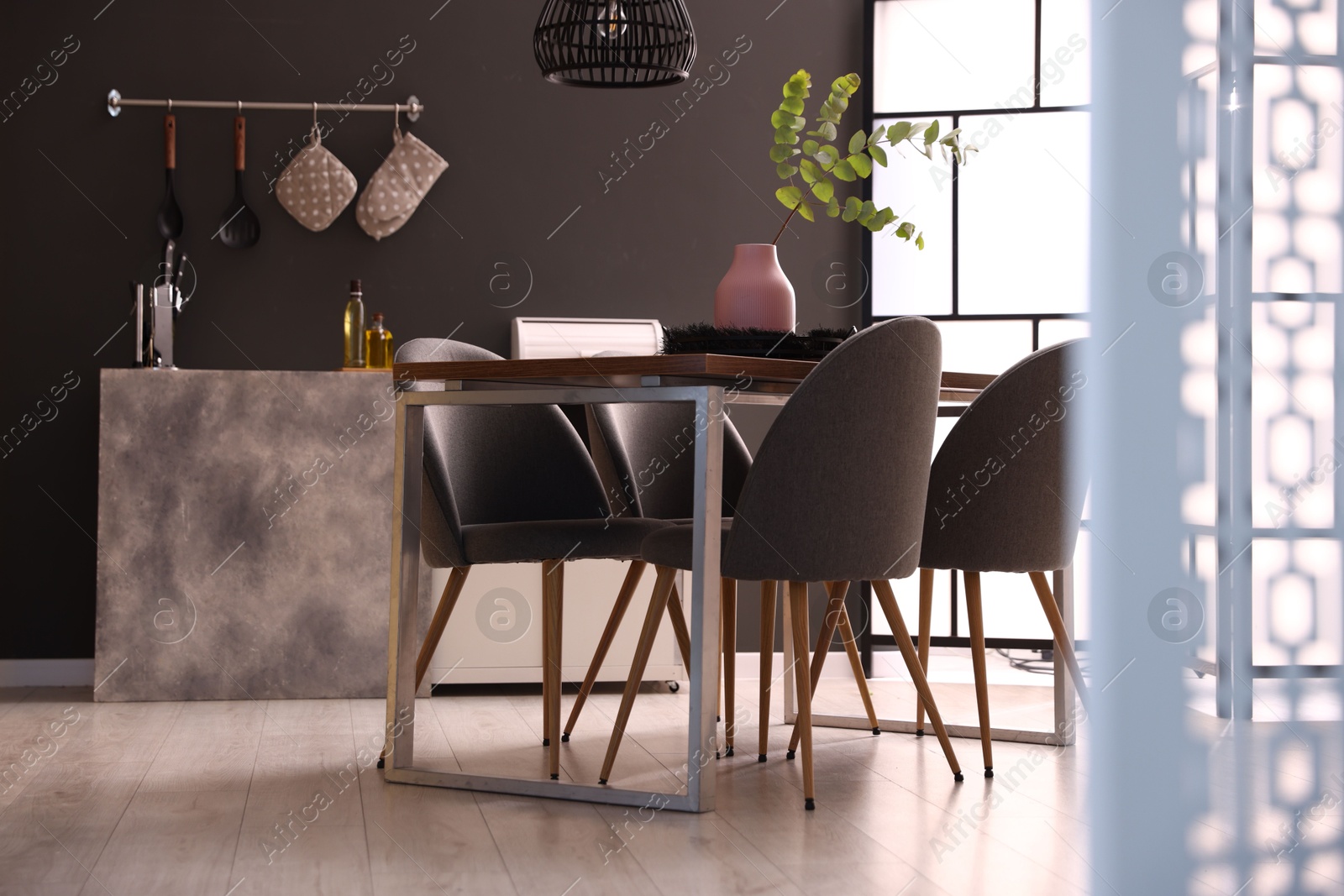 Wooden table with chairs and floral decor in dining room. Interior design Photo of Wooden table with chairs and floral decor in dining room. Interior design