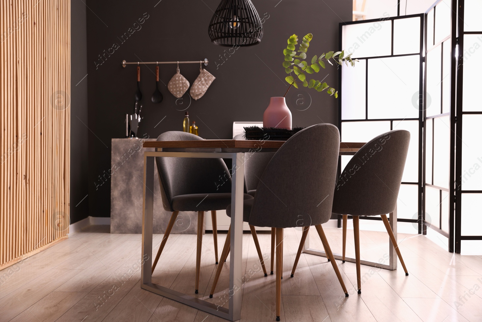 Wooden table with chairs and floral decor in dining room. Interior design Photo of Wooden table with chairs and floral decor in dining room. Interior design