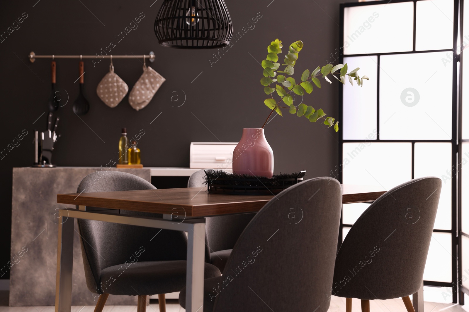Photo of Wooden table with chairs and floral decor in dining room. Interior design