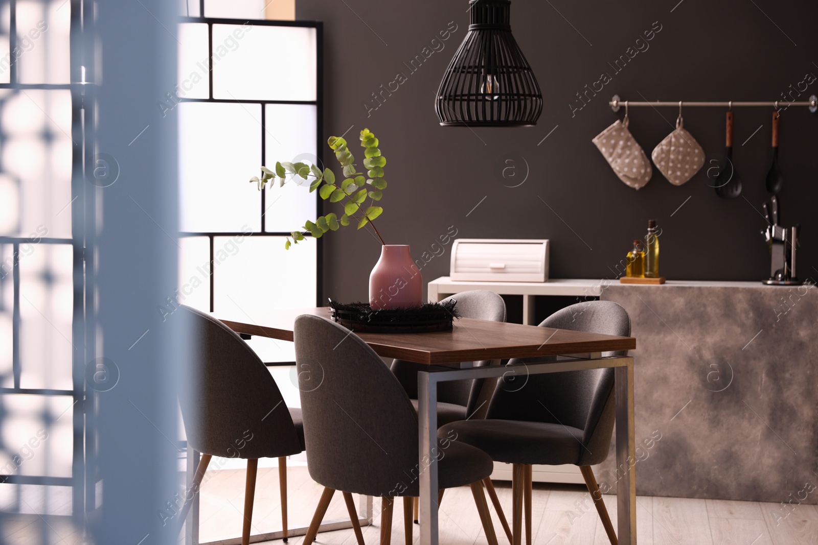 Wooden table with chairs and floral decor in dining room. Interior design Photo of Wooden table with chairs and floral decor in dining room. Interior design