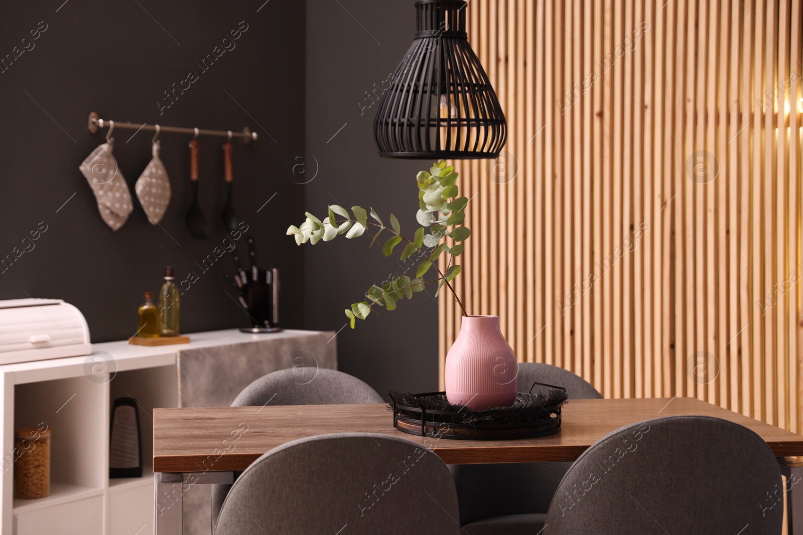Wooden table with chairs and floral decor in dining room. Interior design Photo of Wooden table with chairs and floral decor in dining room. Interior design