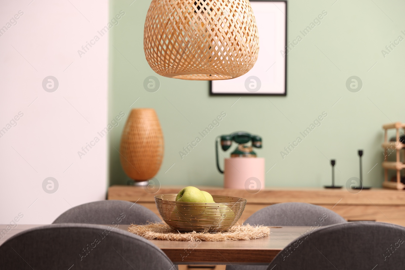 Photo of Wooden table with chairs and apples in dining room. Interior design