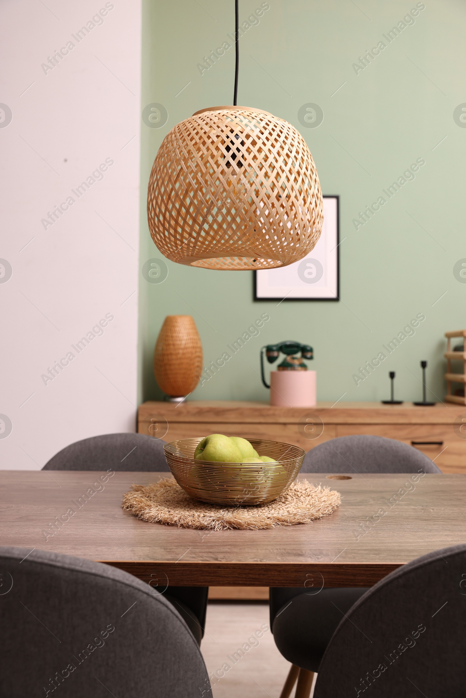 Photo of Wooden table with chairs and apples in dining room. Interior design