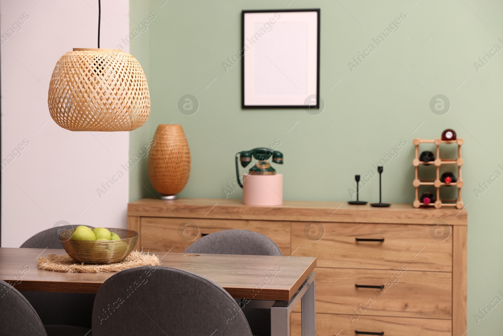 Photo of Wooden table with chairs and apples in dining room. Interior design