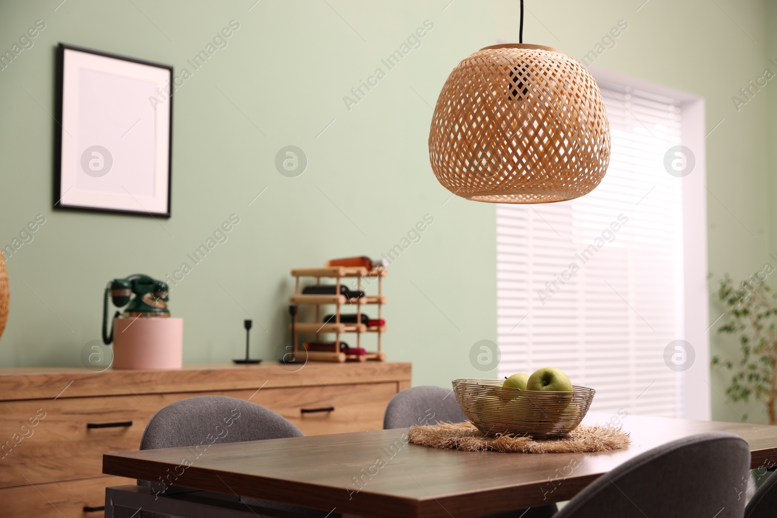 Photo of Wooden table with chairs and apples in dining room. Interior design