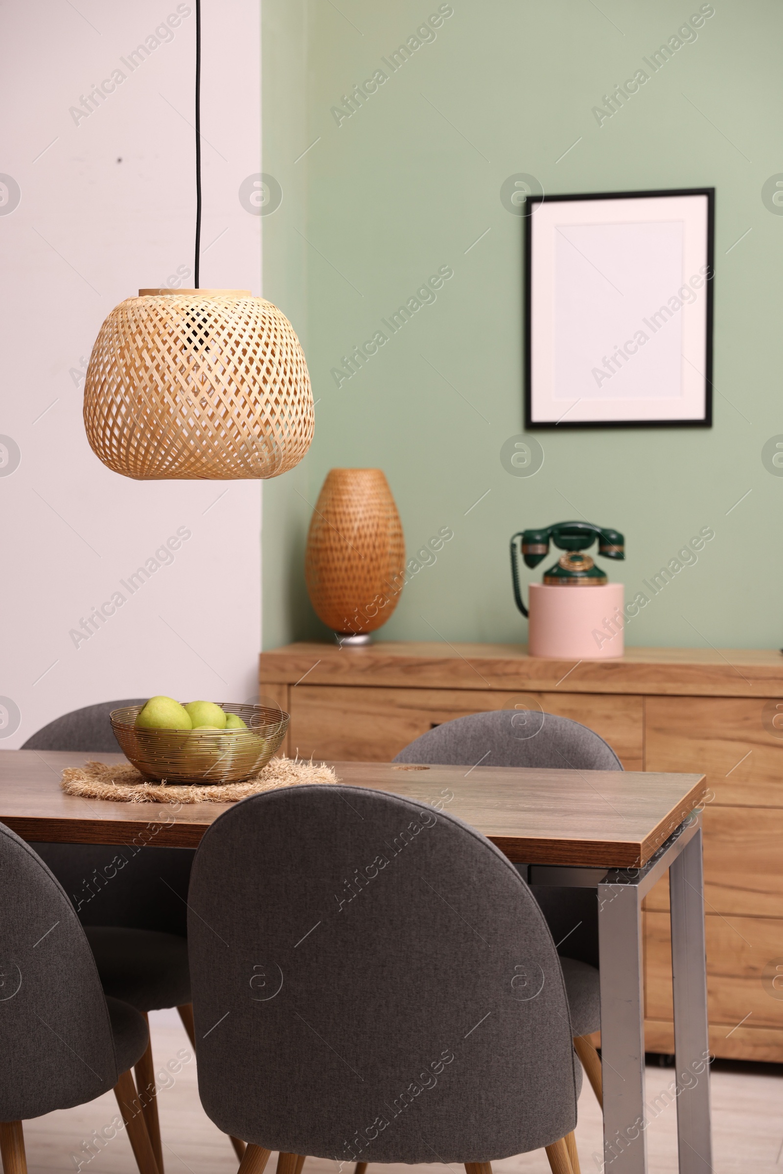 Photo of Wooden table with chairs and apples in dining room. Interior design